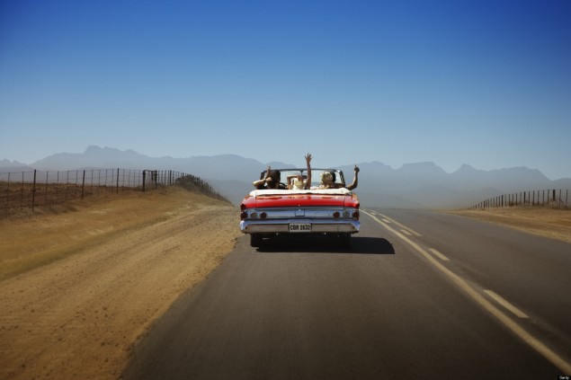 A car with three celebratory passengers in it drives off into the desert during a road trip.