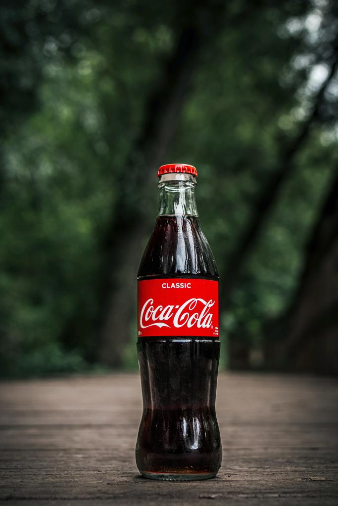 A close up of a glass Coca-Cola bottle